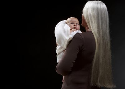 grauhaarige Frau mit Baby für Werbefotos